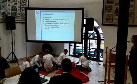 zu sehen ist eine Gruppe des JRK bei der Rede zum 40jährigen Jubiläum