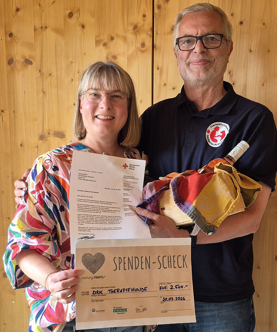 Claudia Böhler/Kinderhaus Jahnareal übergibt die Spende an Norbert Mezger vom DRK-Therapiehundedienst.