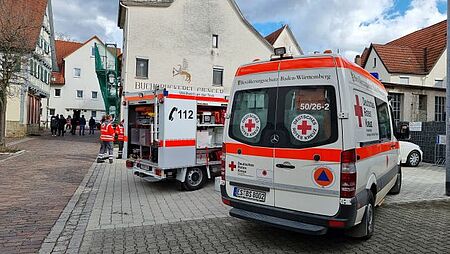 zu sehen sind zwei DRK Fahrzeuge und einige Helfer im Einsatz wegen Gasaustritt